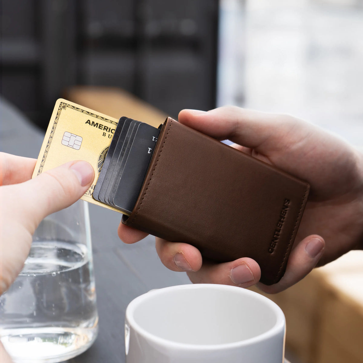 G004-cardholder-darkbrown;;Cartes éjectées du Cardholder en marron foncé, une tasse à l'arrière-plan;;;fr